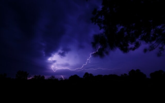 Picture of lightning at night lighting up the sky.